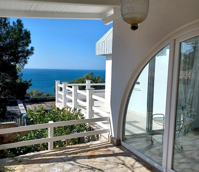 Eladó egy villa terasza, kilátással az Adriai-tengerre a horvátországi Cres szigeten, fehér korlátokkal és fákkal