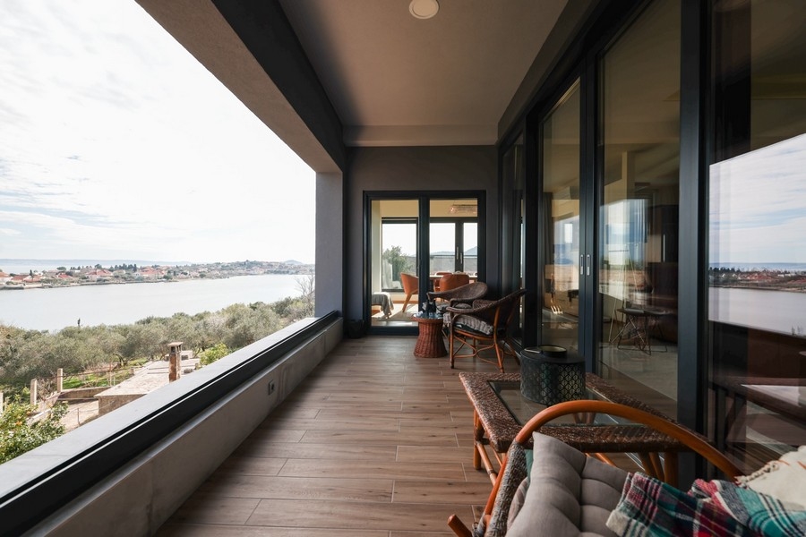 Ugljanban eladó egy villa fedett terasza kényelmes ülőhellyel és panorámás kilátással az Adriai-tengerre.