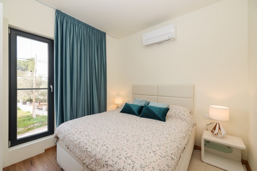 Kétágyas hálószoba világos színekkel és ablakra néző villában Ugljan szigetén, eladó.