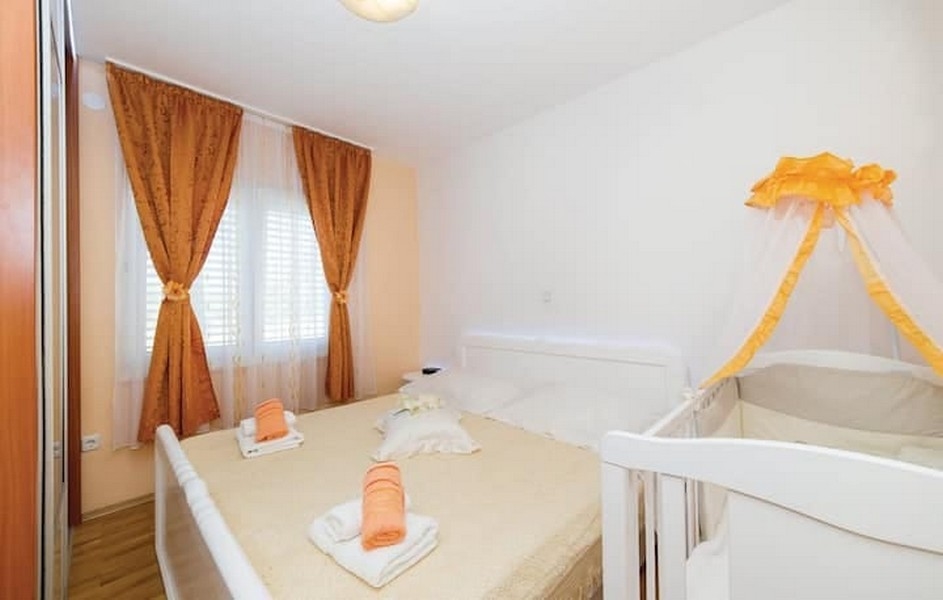 Hálószoba franciaággyal és babaággyal egy bérházban Kaštel Lukšićban, Horvátországban