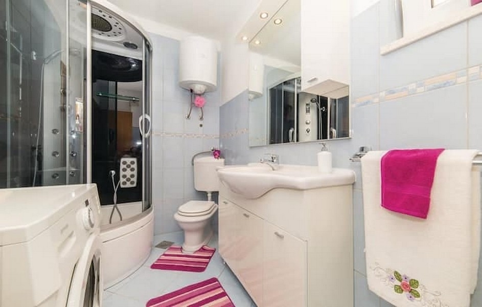 Fürdőszoba zuhanykabinnal és mosógéppel egy bérházban Kaštel Lukšićban, Horvátországban