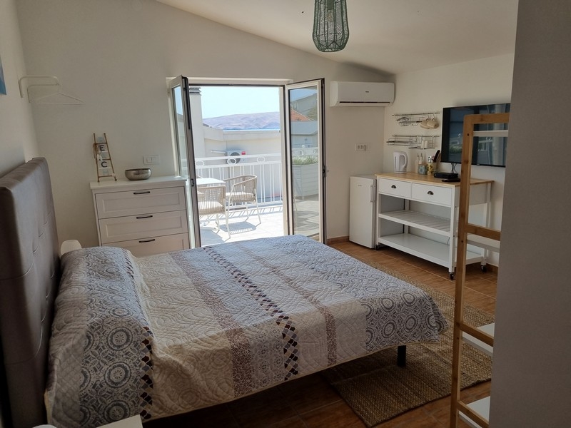 Világos garzonlakás franciaággyal, beépített konyhával, tengerre néző erkélyajtókkal eladó a horvátországi Karlobagban, közvetlenül a tenger mellett egy bérház része.