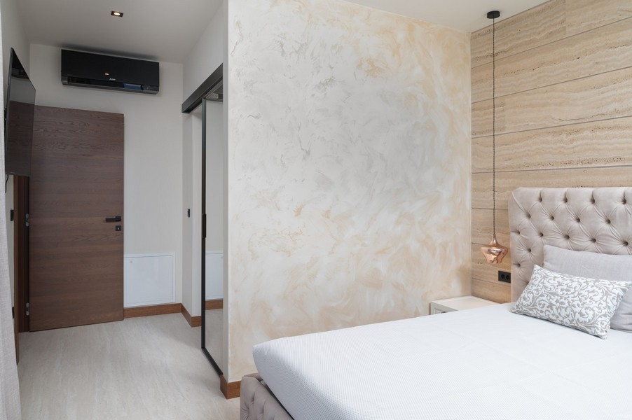 Modern kialakítású hálószoba kárpitozott fejtámlával egy villában Razanacban, Zadar régióban, Horvátországban, tolóajtóval a folyosóra