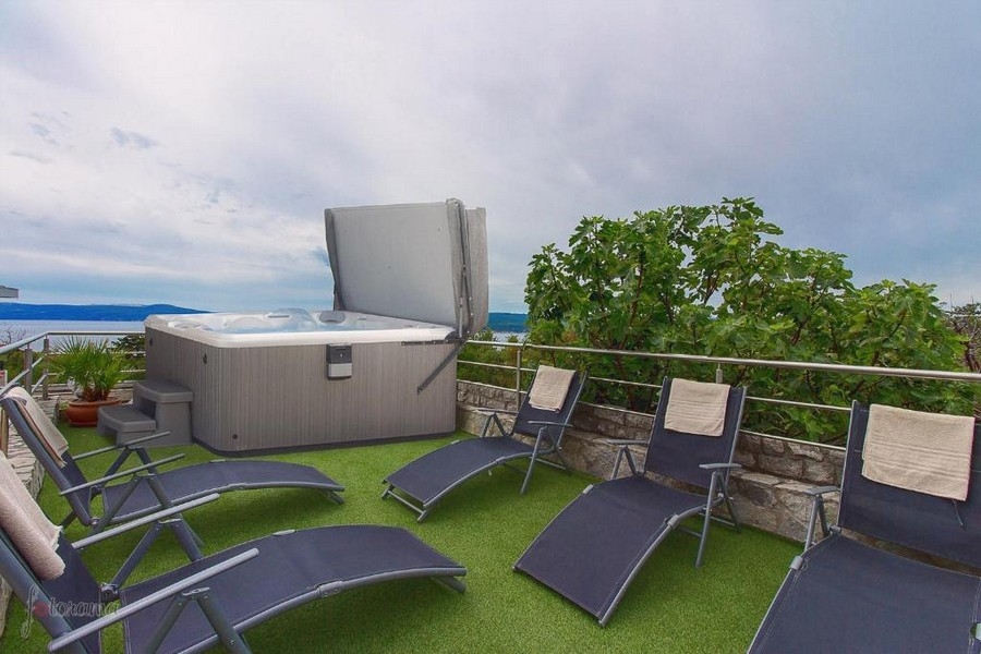Tetőterasz jakuzzival és nyugágyakkal, tengerre néző ingatlan Horvátországban