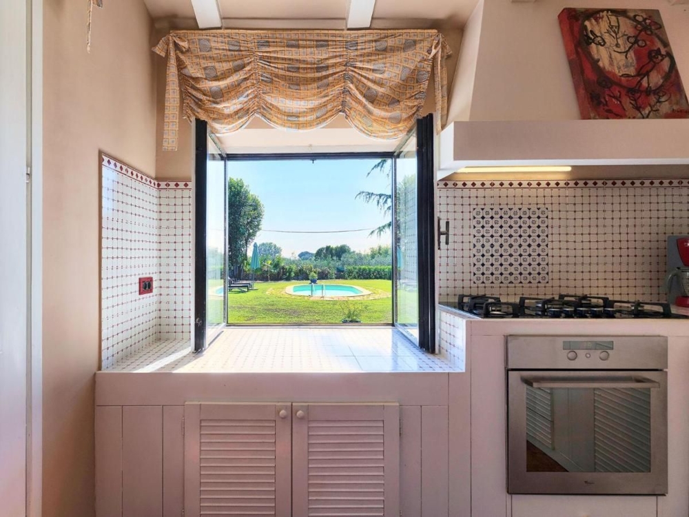 Konyhaablak, kilátással a medencére és a kertre, a horvátországi ingatlanok kiemelése