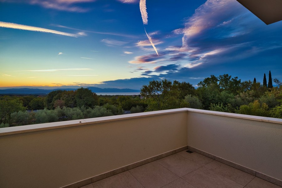Erkélyes kilátás a Krk-szigeti ingatlanra, panorámás kilátással a festői tájra alkonyatkor