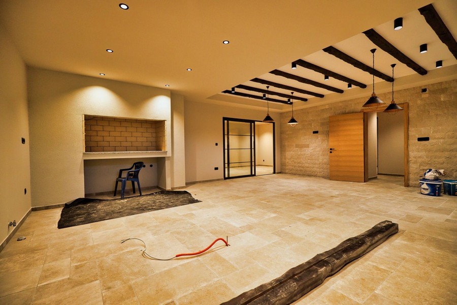 A Krk-szigeti ingatlan belső kialakítása modern padlóval és előkészített kandallóval