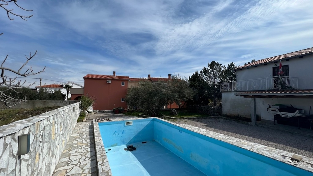 Ingatlan Horvátország, Krk város, Krk sziget Lakásház vásárlása, a ház hátulnézete üres medencével és kerttel