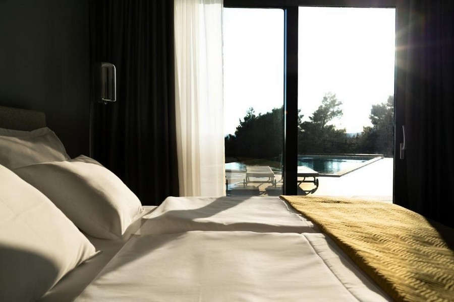 Hálószoba egy exkluzív villában, közvetlen kilátással a medencére és sok természetes fénnyel. Az isztriai Labinban található.