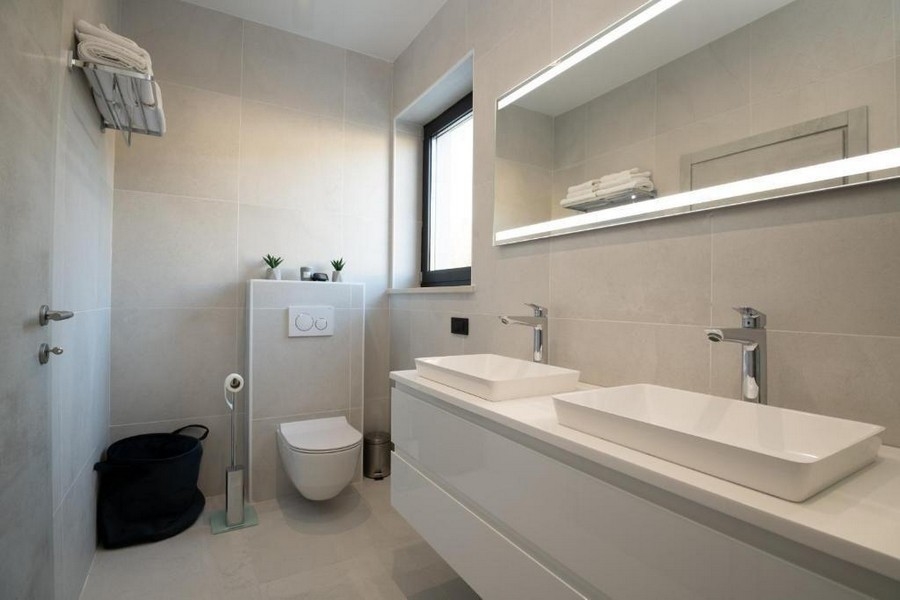 Világos, modern kialakítású fürdőszoba dupla mosdóval és minimalista dekorációval az isztriai Labinban található villában.