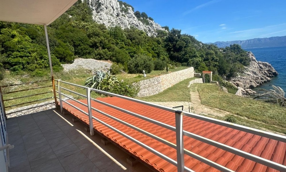 Villa fehér homlokzattal, mediterrán növényzettel és kőívvel körülvéve, a Pelješac-félsziget