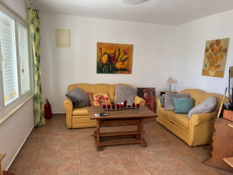 Tágas nappali sárga kanapékkal és dekoratív festményekkel egy tengerparti villában, a Pelješac-félszigeten