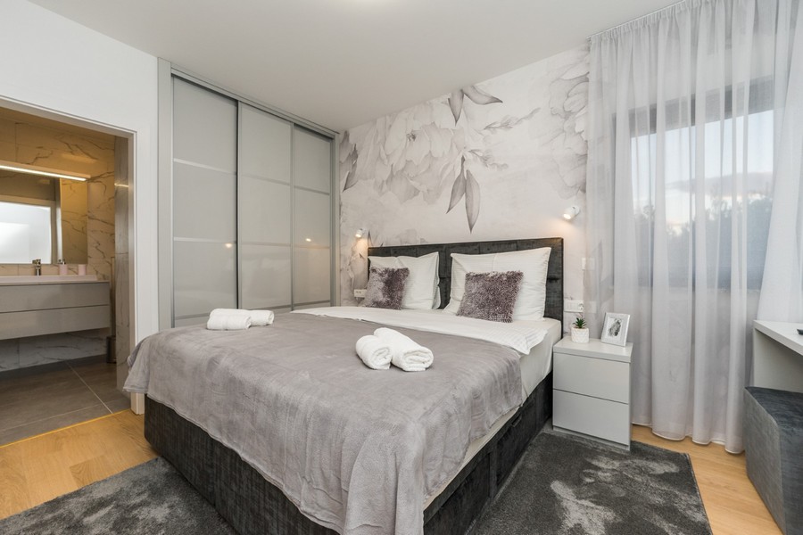 Ízlésesen berendezett hálószoba saját fürdőszobával egy kiváló horvátországi ingatlanban.