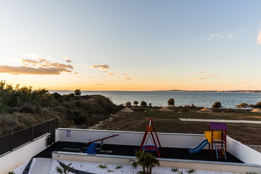 Lenyűgöző kilátás nyílik a tengerre egy gyönyörű horvátországi ingatlan kertjéből, játszótérrel.