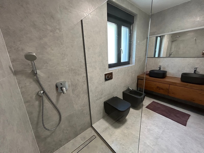 Nagy fürdőszoba küszöb nélküli zuhanyzóval, bidével és modern felszerelésekkel