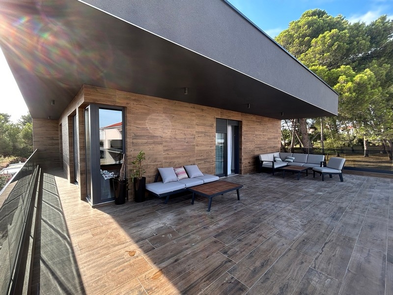 A villa nagy terasza ülőhellyel és kilátással a környező fákra