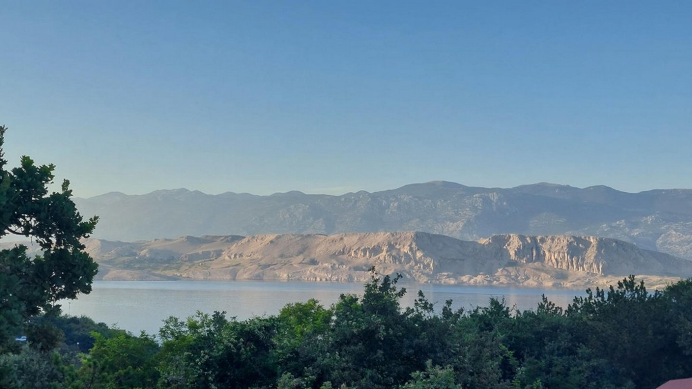 Lenyűgöző kilátás nyílik a tengerre és a környező hegyekre egy erkélyről Horvátországban