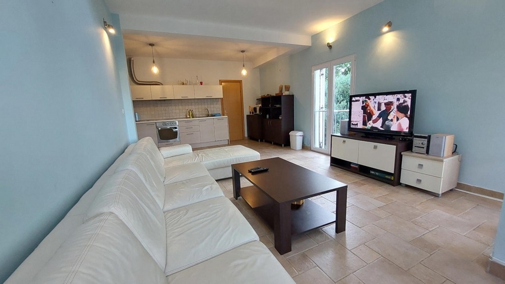 Nappali fehér kanapéval, dohányzóasztallal és TV-vel egy horvátországi házban