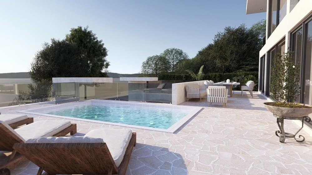 Egy modern villa terasza úszómedencével, napozóágyakkal és szabadtéri ülősarokkal, buja növényzettel körülvéve Drage-ben, Horvátországban.