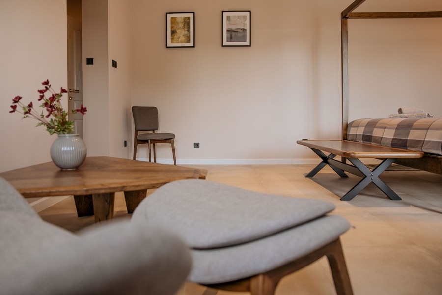 Modern és elegáns hálószoba íróasztallal, falra szerelt TV-vel és nagy tükörrel, lágy világítással és semleges tónusokkal