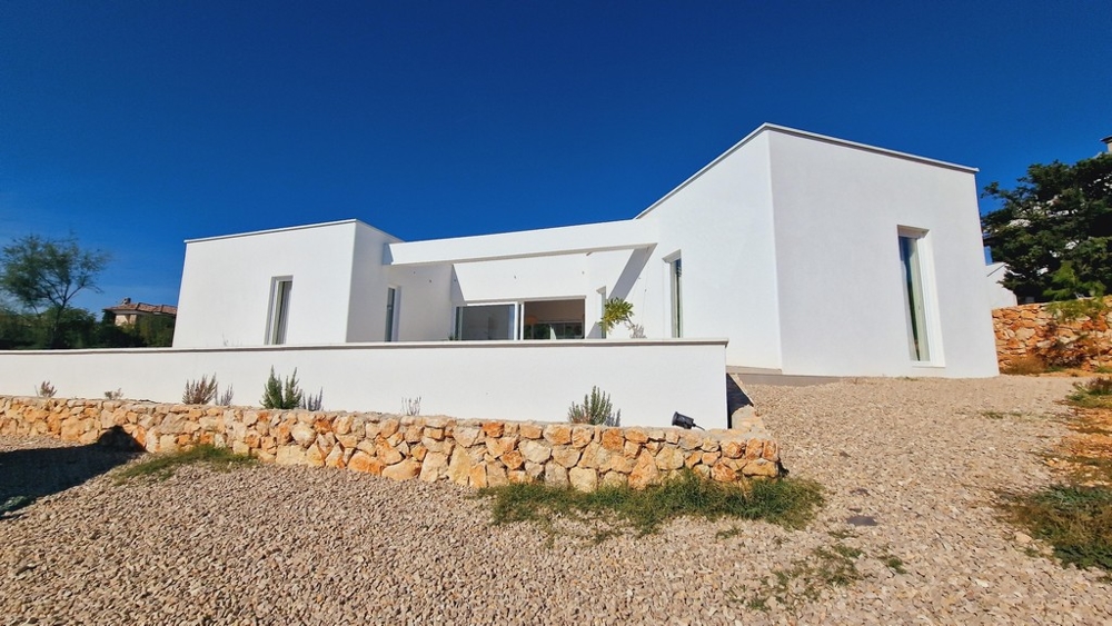 Modern egyszintes villa Horvátországban fehér homlokzattal és kavicsos úttal