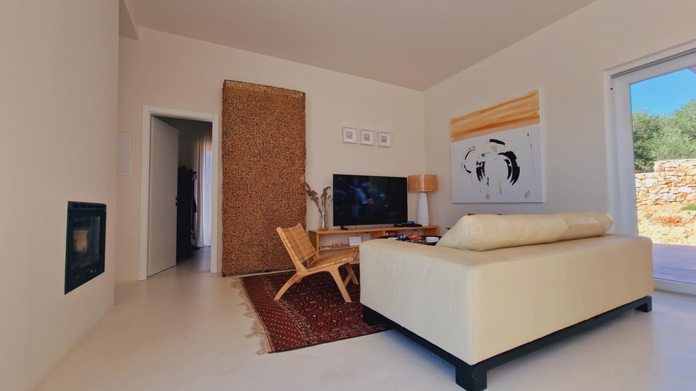 Nappali krémszínű kanapéval, televízióval és dekoratív műalkotásokkal