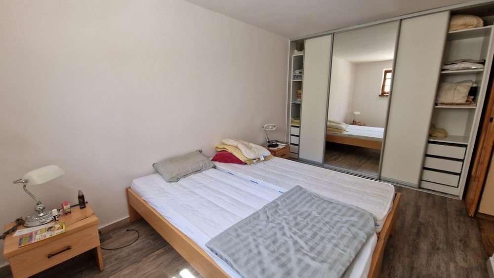 Hálószoba franciaággyal, nagy gardróbbal és minimalista bútorokkal.