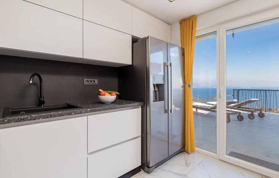 Modern konyha tengerre néző kilátással és sárga függönyökkel