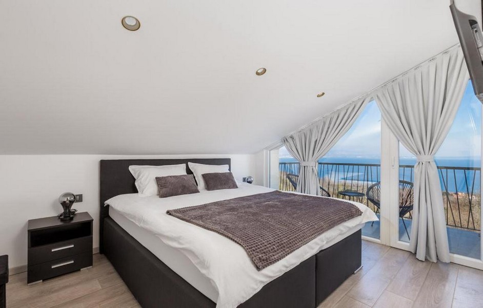 Hálószoba ferde mennyezettel és kilátással a tengerre