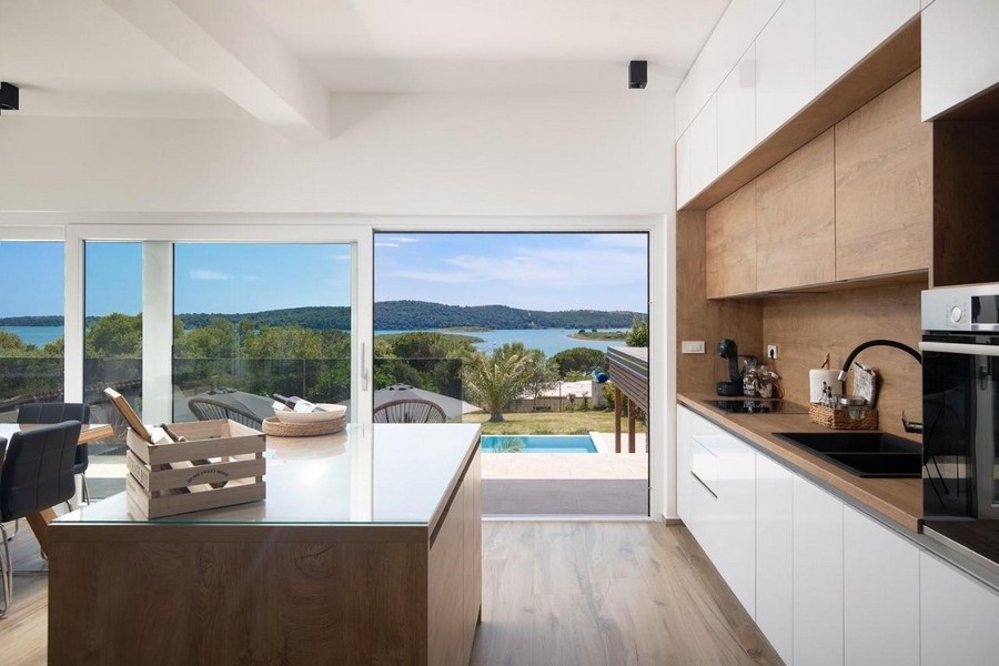 Modern konyha, kilátással a medencére és a tengerre.