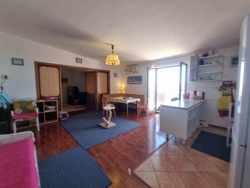 Nyitott nappali fapadlóval, közvetlen kijárattal a teraszra, kényelmes ülő- és étkezősarokkal.