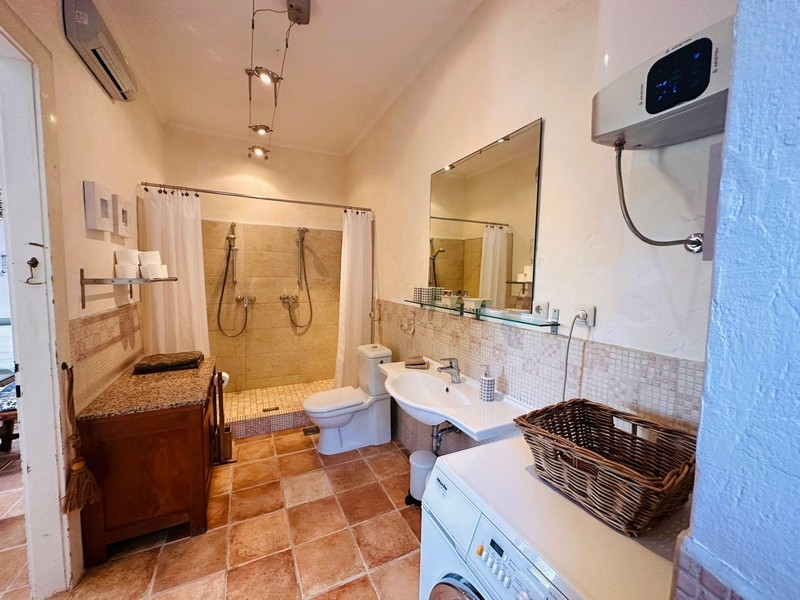 Nagy fürdőszoba zuhanyzóval és mosógéppel