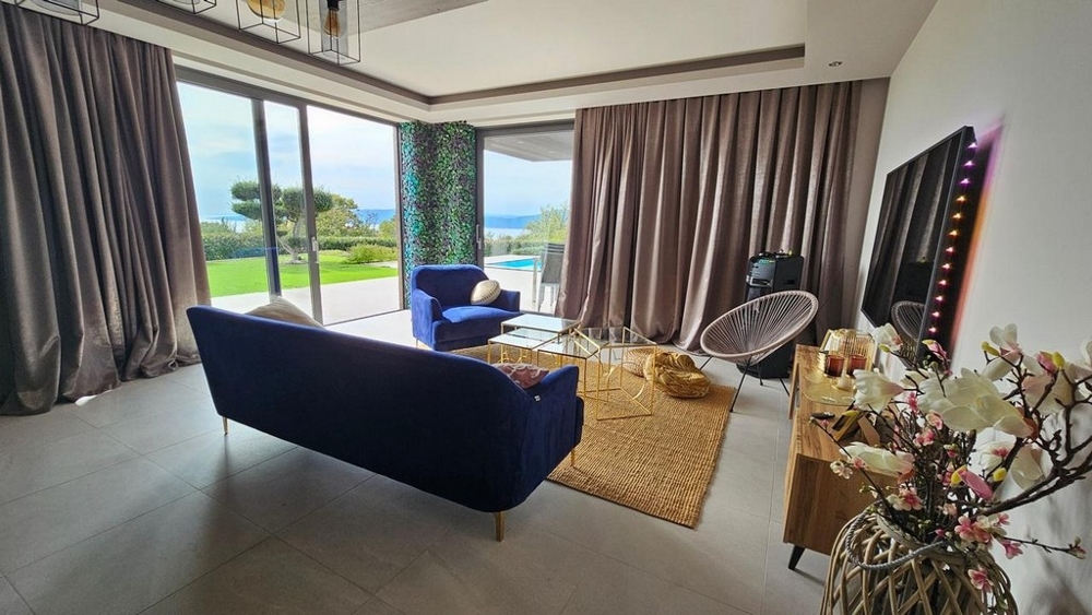 Nappali kilátással a medencére és a tengerre.