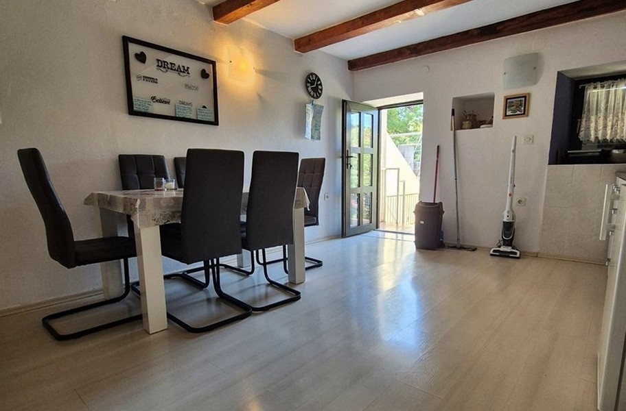 Világos étkező modern bútorokkal és fagerendákkal.