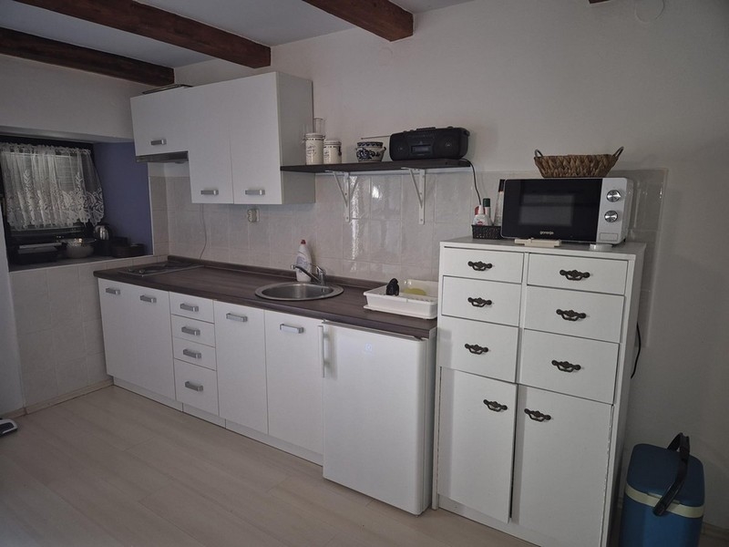 Modern fehér konyha kis szekrényekkel és polcokkal.