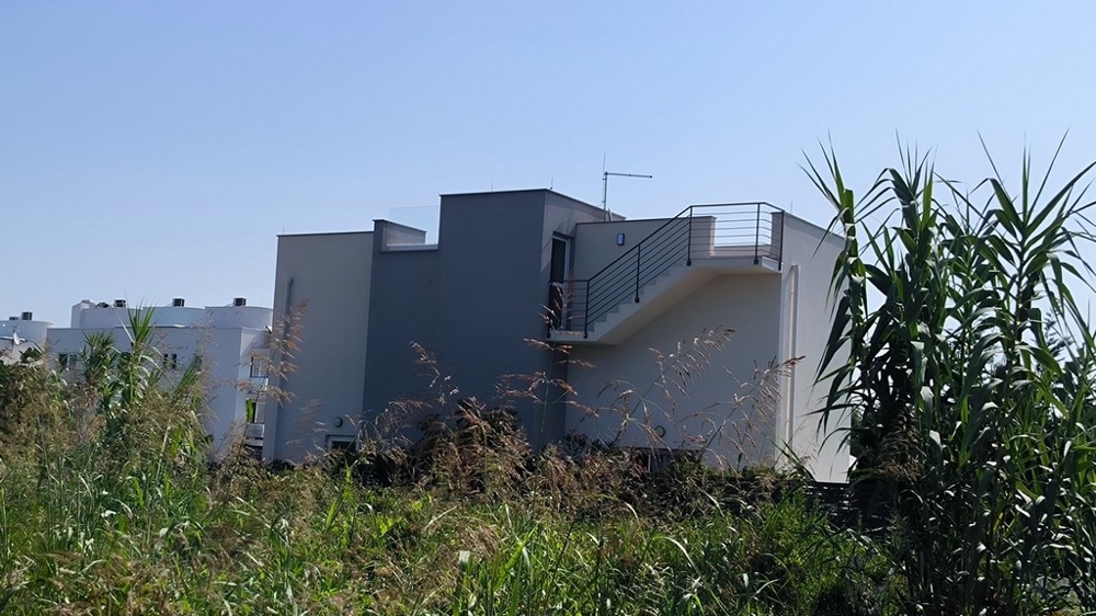 A ház hátulnézete terasszal és lépcsőkkel az emeletre.