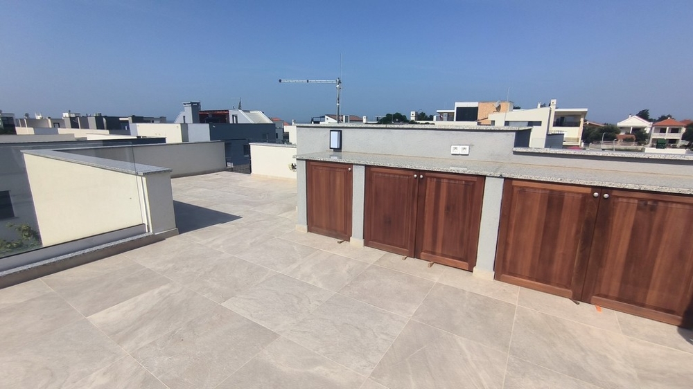 Tágas tetőterasz beépített fabútorokkal.