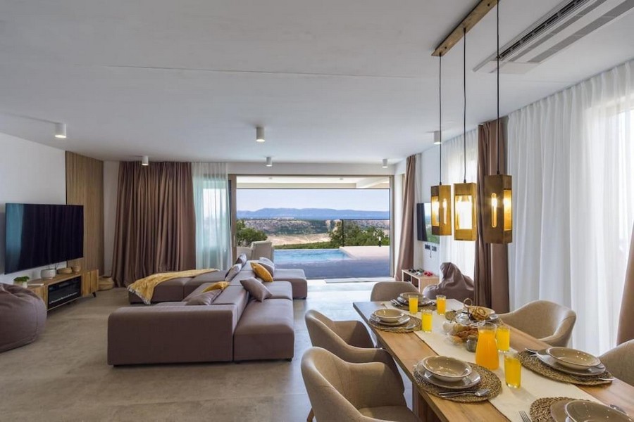 Modern és fényűzően berendezett nappali étkezővel és kilátással a medencére.