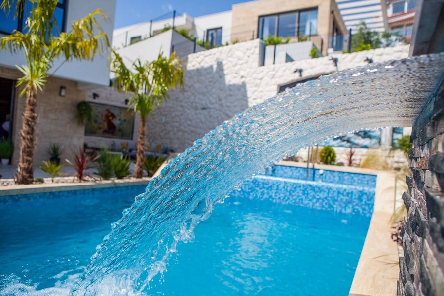 Vízesés a H3515 ingatlan medencéjében, Splitben, Horvátországban.