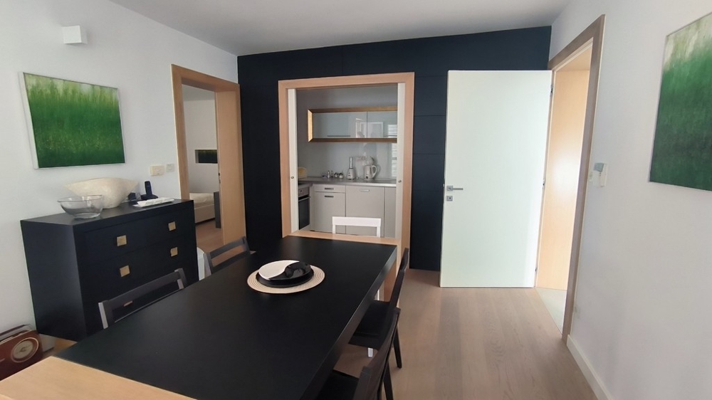 Étkező sötét asztallal és konyhával összekötve