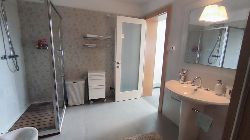 Modern fürdőszoba nagy zuhanyzóval és tükörrel