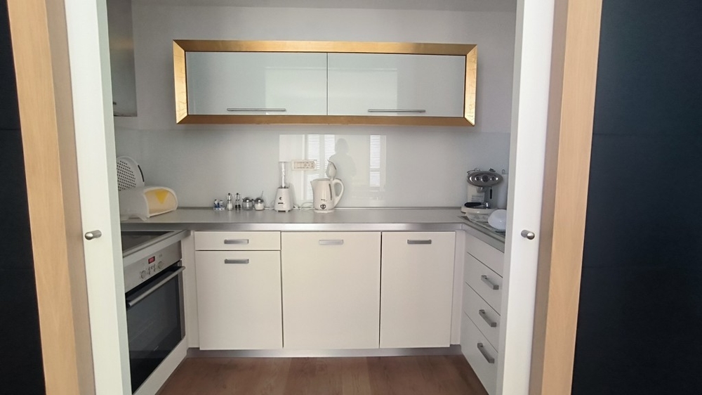 Kompakt konyha fehér beépített bútorokkal és arany díszítéssel