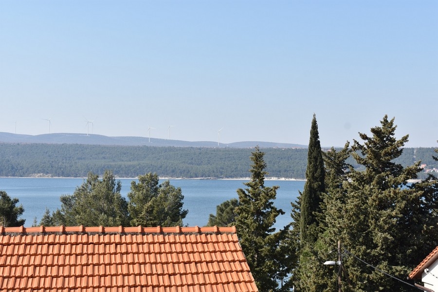 Tengerre néző kilátás a háztetőkre és a fenyőfákra