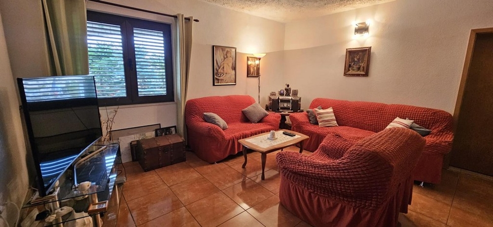 Nappali ülőgarnitúrával és televízióval