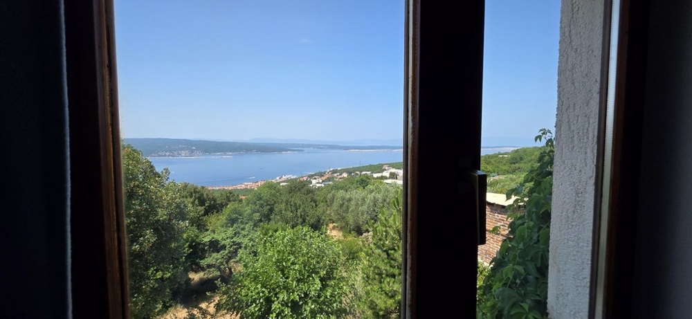 Tengerre néző ablakon keresztül a zöld domboldalon