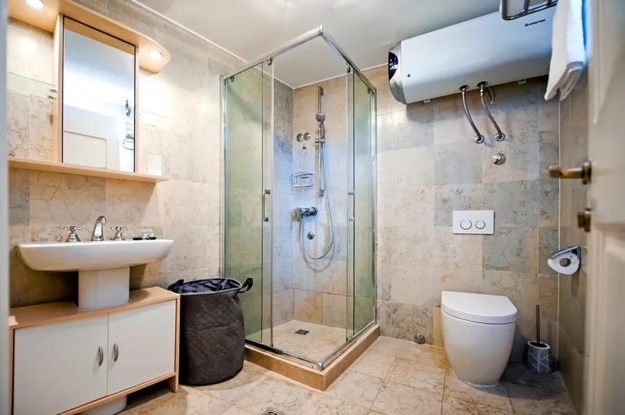 Fürdőszoba zuhanyzóval és csempézett padlóval