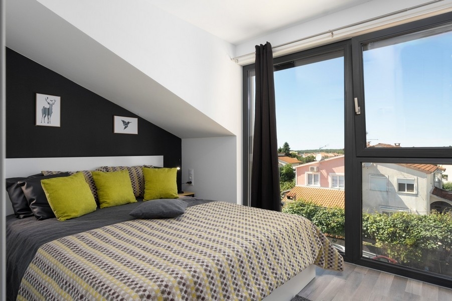 Tetőtéri hálószoba nagy ablakkal és kilátással