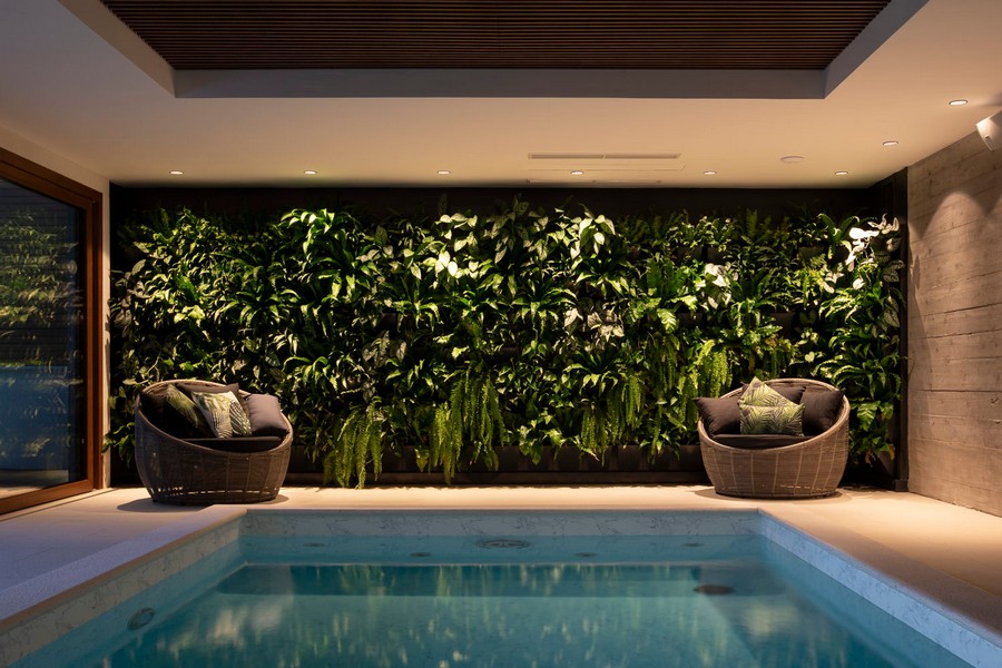Fedett medence zöld növényfallal és ülősarokkal