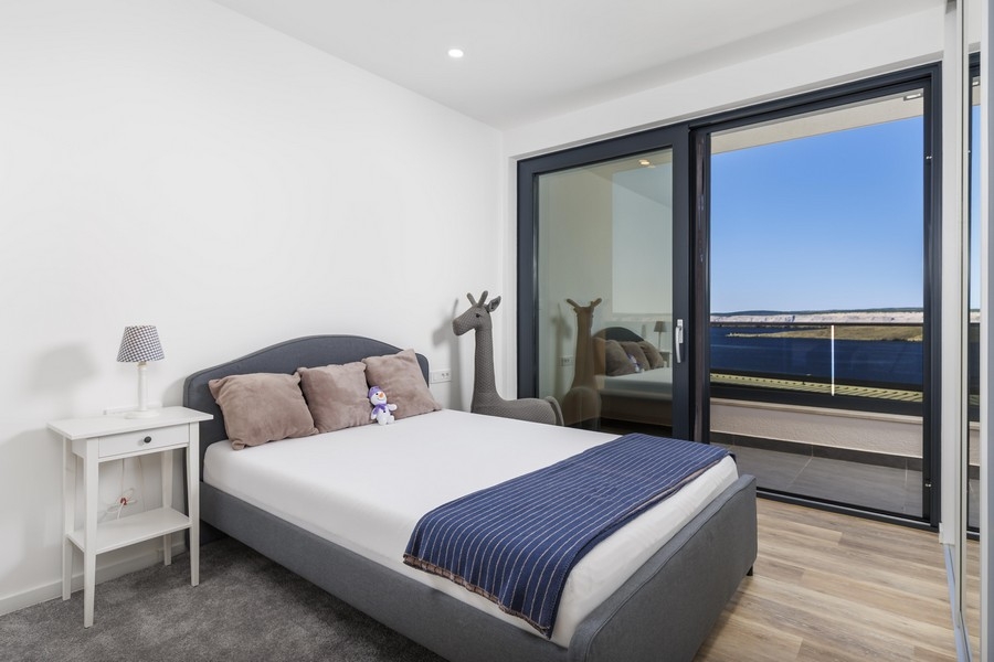 Világos hálószoba erkéllyel és kilátással a tengerre