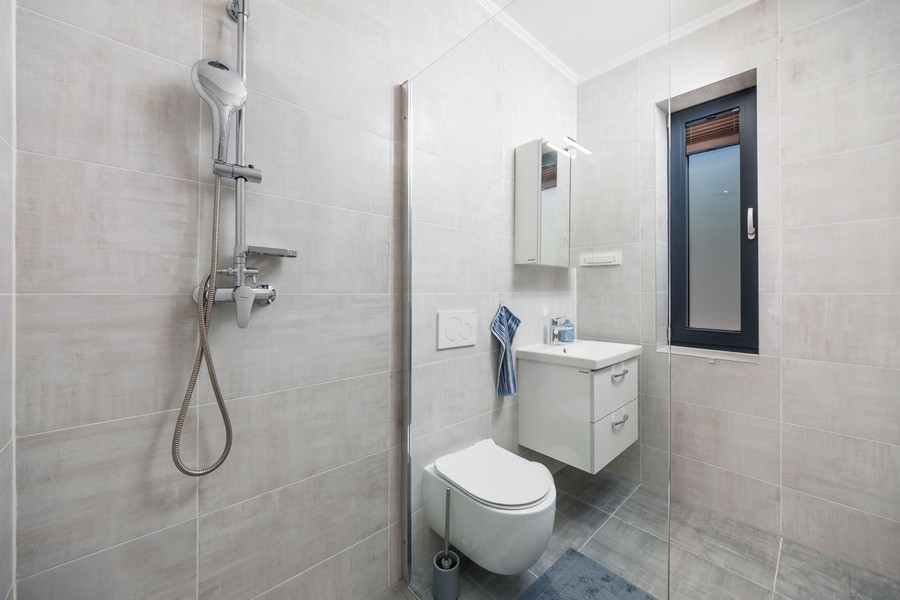 Modern fürdőszoba zuhanyzóval és ablakkal